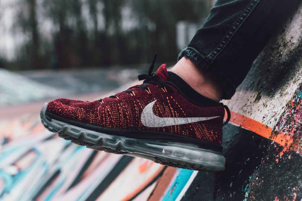 close up photography of red and black nike running shoe